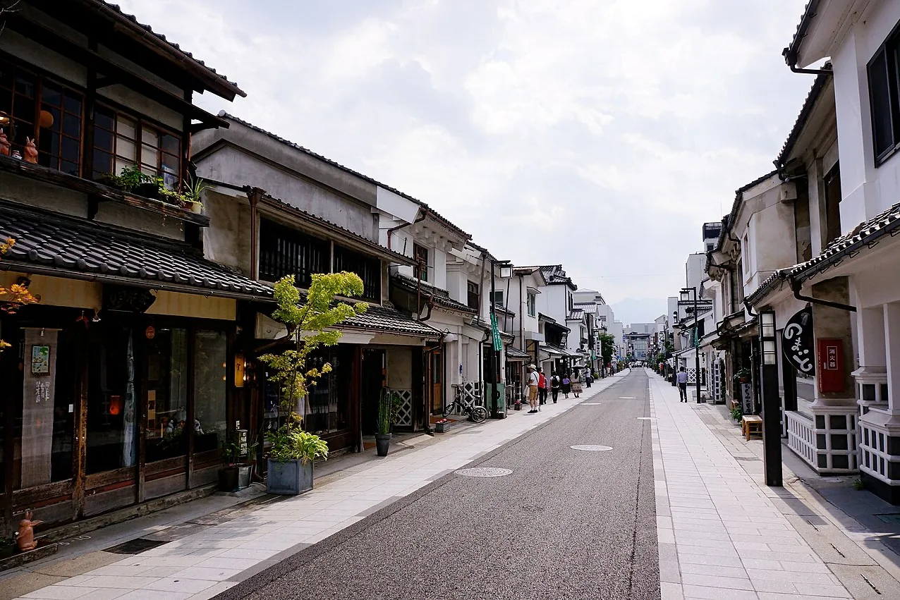 Old white-walled and dark wooden shophouses lining Nakamachi Street in Matsumoto
