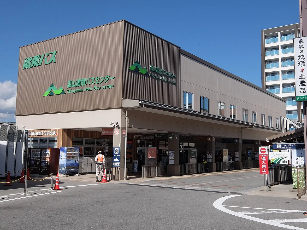 The front of Takayama Nohi Bus Center, with numbered bus bays and a coin locker sign