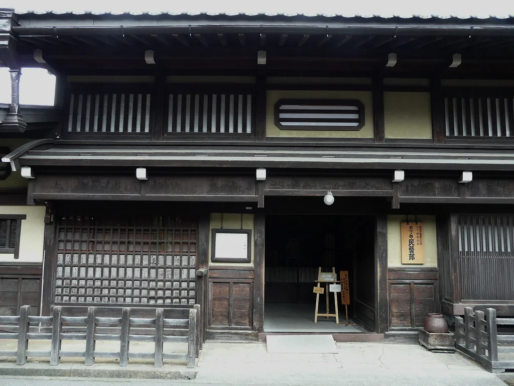 The dark wooden front of the Kusakabe Folk Museum in Takayama, with latticed windows and an open doorway